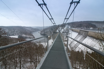 Fototapeta na wymiar Hanging rope bridge at the Rappbodetalsperre in the Harz low mountain range, Germany. At 440 metres, it is the longest of its kind in the world. 
