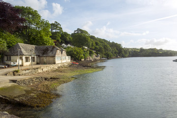 Fototapeta na wymiar Peaceful early summer morning on picturesque boat moorings in the Helford Estuary at old fashioned Port Navas, Cornwall, UK