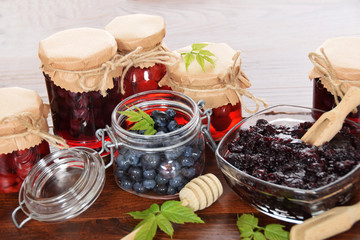 homemade blue marmalade with sugar and honey good for winter colds and jars full of raspberries in sweet syrup for tea for illness