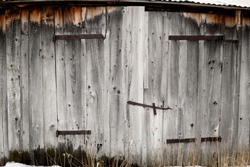 Weathered wood and rusted hinges on an old barn on a farm