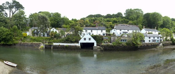 Picturesque old cottages line the waters edge in Helford village on the Helford Estuary in Cornwall, UK