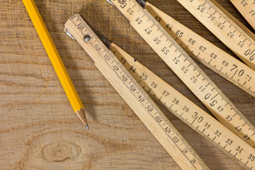 Measuring Stick and Pencil on a Wooden Table