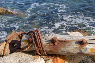 Rusted Wire on Log by Coast