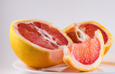 Fototapeta na wymiar Mature grapefruit on a white plate close-up