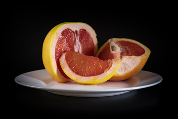 Mature grapefruit on a white plate close-up