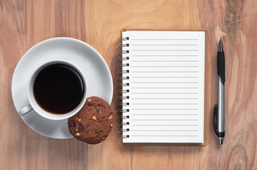 Notebook and coffee with cookie
