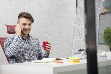Fototapeta premium Young happy businessman smiling while reading his smartphone.