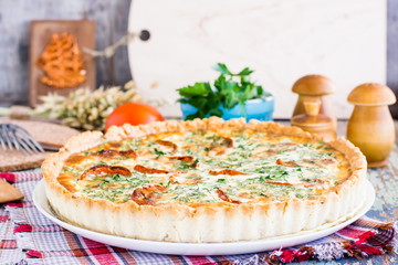 Homemade french quiche pie with tomato, cheese and herb on a plate