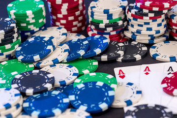 Poker chips mixed with cards on the table .