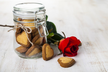 Heart-shaped cookies in a glass jar and red roses