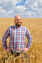 Naklejka na ściany i meble Farmer standing in wheat field