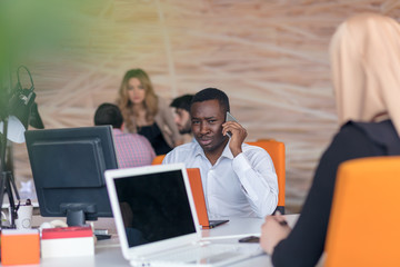 Happy smiling successful African American businessman in in a modern bright startup office indoors