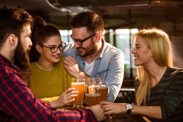 Friends in pub drinking beer having fun 