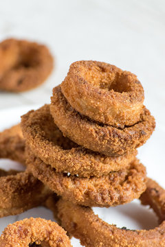 Breaded Onion Rings In Stack On White Background