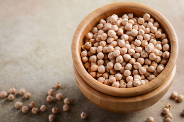 Raw organic chickpeas in a wooden bowl, healthy vegan vegetarian food ingredient.