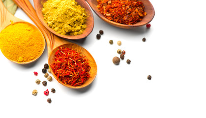 Spice. Various spices in wooden spoons over white background. Curry, saffron, turmeric, cinnamon