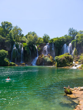 BOSNIA AND HERZEGOVINA - JUNE 01/2017: tourists rest and swim in the Kravice waterfall in the National Park.