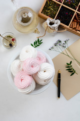 Homemade zephyr or marshmallow in white plate with cup of tea on white table. Marshmallow, Meringue, Zephyr. Valentine's or Mothers Day concept.