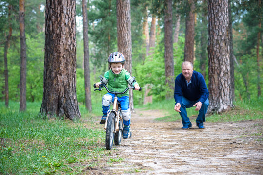 Little kid boy of 3 years and his father in autumn forest with a