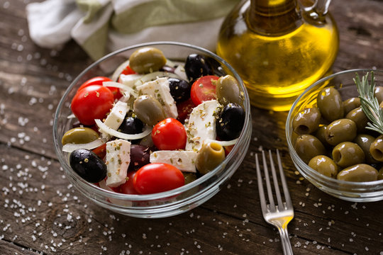 Greek salad with fresh vegetables, feta cheese and green olives wooden table .