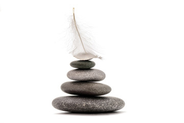 Meditation stones and plume isolated on white background. Stone balance with plume.