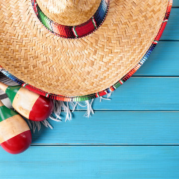 Cinco de mayo mexican background border with mexico sombrero straw hat blanket rug and maracas on old blue wood fiesta festival photo square format