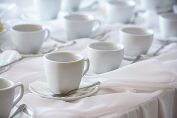 Fototapeta na wymiar Many white coffee cups in a line over a buffet
