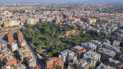 Aerial view of Villa Lazzaroni, a small park located between the tuscolana palaces in Rome, Italy. There is a building, a villa, within this green city area.