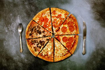 Slices of pizza with different fillings on a dark textured background