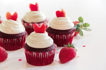 Homemade Red velvet cupcakes with frosting and strawberry heart on white background
