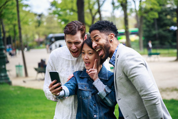 Multi-ethnic Group Of Friends Having Fun In Park Near Eiffel