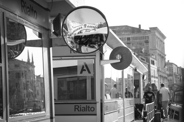 in the mirror of the vaporetto station in Venice the famous Rialto Bridge is reflected - obrazy, fototapety, plakaty