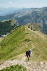 Fototapeta na wymiar Hikers Walking On Trail Of Mountain Ridge, Montenegro