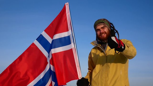 Close-up of a Norwegian against a blue sky with the flag of Norway. Support for the national team