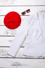 Female red beret and white blazer. Stylish clothes and accessories for ladies. Feminine fashion background.