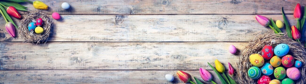 Tulips And Painted Eggs In Nests On Vintage Plank
