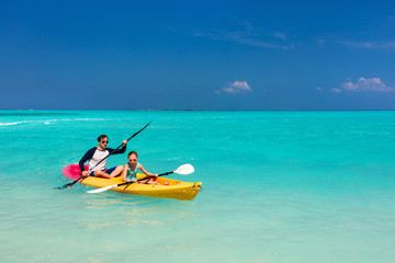 Family kayaking at tropical ocean