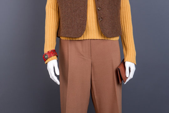 Female mannequin with brown clothes and purse. Women casual outfit and fashion accesories. Feminine classic garment.