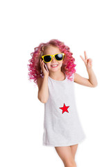 Colored wavy hairs. Little modern hipster girl in fashion clothes an sunglasses make peace by her hand.