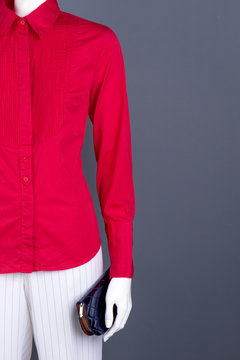 Mannequin in women clothing, copy space. Red women blouse, white trousers and wallet. Ladies classy clothes and accessories.