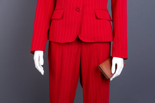 Female elegant suit and leather wallet. Manneqin in female red blazer and pants, cropped image. Fashion design outfit for ladies.