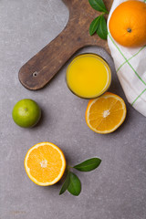 Glass of fresh orange juice with kitchen utensils on the dark stone table. Tonned image. Flat lay.