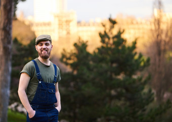 Handsome smiling bearded man in green hat in garden