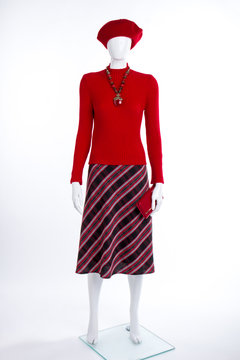 Red beret, sweater and wallet. Female mannequin with red pullover and striped skirt on white background. Ladies elegance and style.