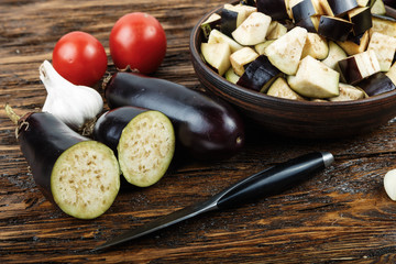 raw diced eggplant in a bowl, tomato and garlic, detail of a cut