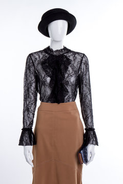 Hat, blouse and skirt on mannequin. Female mannequin with lace blouse, skirt and wallet. Black hat and jabot blouse.