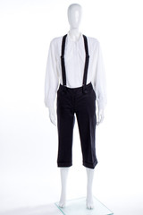 White shirt and black trousers with suspenders. Female mannequin dressed in blouse and capri with braces.