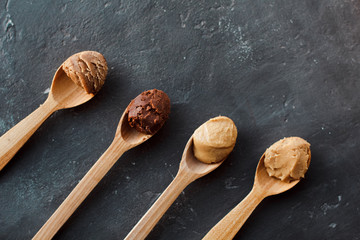 Wooden spoon with peanut butter on a dark background