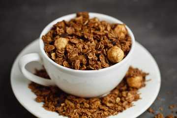 Granola in a white Cup on a black background. The concept of a healthy diet, weight loss, diet