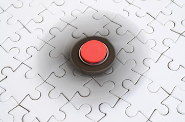 A wooden spinner spins on a white jigsaw puzzle background